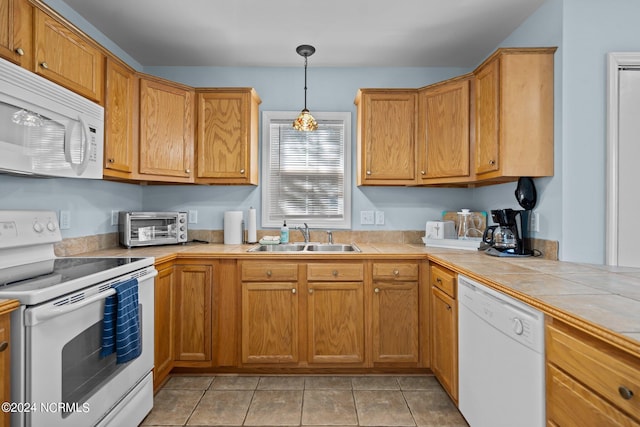 kitchen featuring tile countertops, sink, light tile patterned flooring, pendant lighting, and white appliances