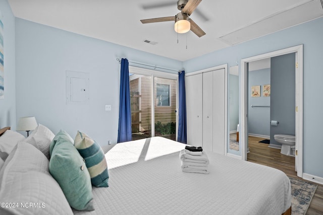 bedroom featuring dark hardwood / wood-style floors, ensuite bath, electric panel, and ceiling fan