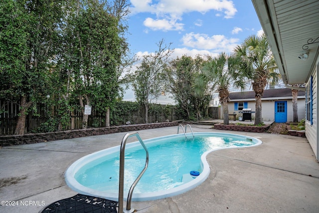 view of swimming pool featuring a patio and a grill