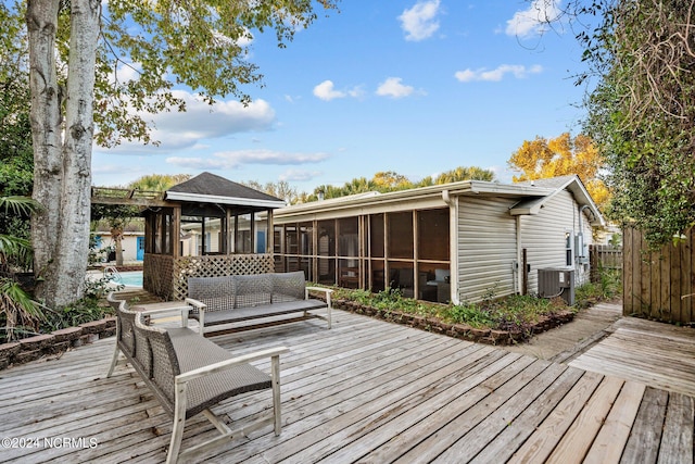 wooden terrace featuring a gazebo, a sunroom, and outdoor lounge area