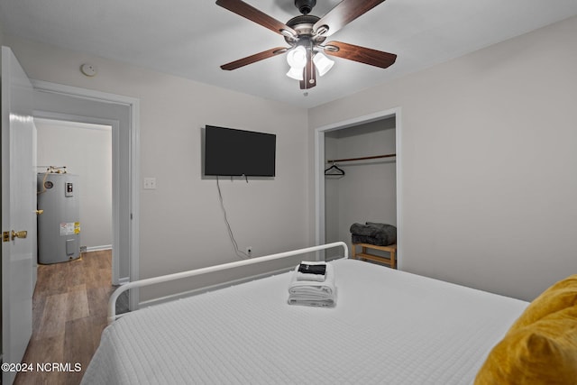 bedroom featuring electric water heater, hardwood / wood-style flooring, a closet, and ceiling fan