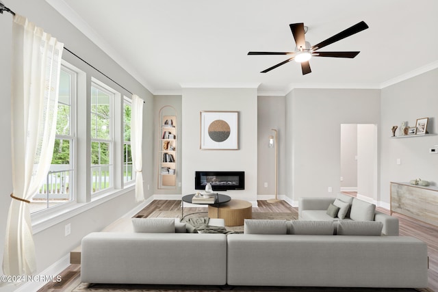 living room with ornamental molding, hardwood / wood-style floors, and ceiling fan