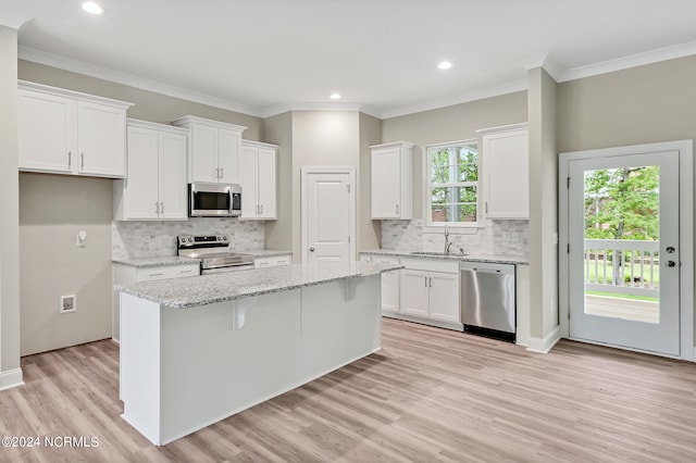 kitchen with light hardwood / wood-style floors, a center island, white cabinetry, and stainless steel appliances