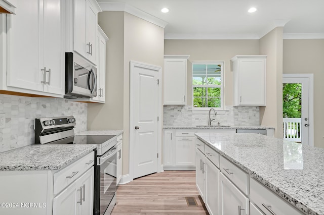 kitchen with light hardwood / wood-style floors, appliances with stainless steel finishes, sink, and white cabinets