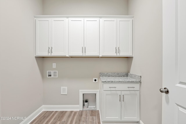 clothes washing area featuring hookup for an electric dryer, light hardwood / wood-style flooring, washer hookup, and cabinets