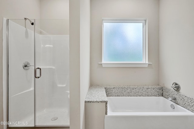 bathroom featuring shower with separate bathtub