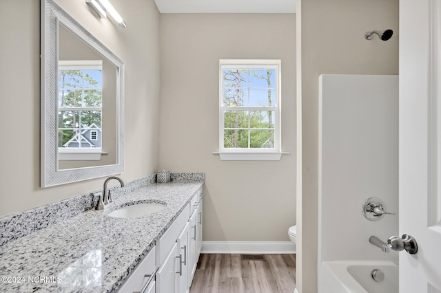 full bathroom with vanity, toilet, a wealth of natural light, and hardwood / wood-style floors