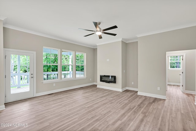 unfurnished living room featuring ceiling fan, a healthy amount of sunlight, ornamental molding, and light wood-type flooring