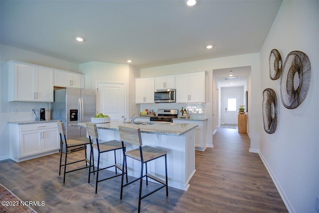 kitchen featuring a kitchen island with sink, dark wood-type flooring, white cabinetry, and stainless steel appliances