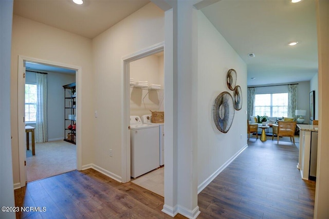 hall with wood-type flooring and washing machine and clothes dryer