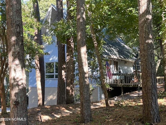 view of property exterior with a wooden deck and a garage