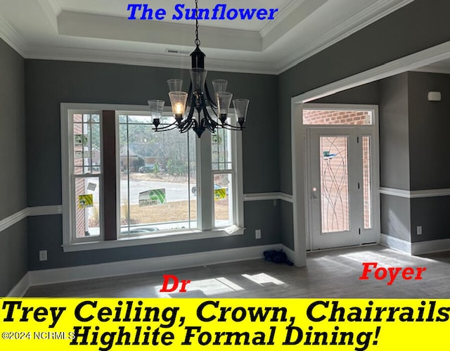 unfurnished dining area featuring a wealth of natural light, ornamental molding, a chandelier, and a tray ceiling