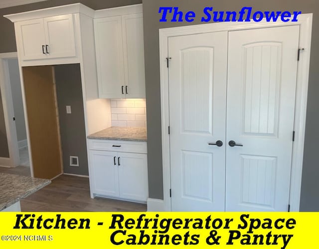 kitchen featuring light stone counters, hardwood / wood-style flooring, decorative backsplash, and white cabinets