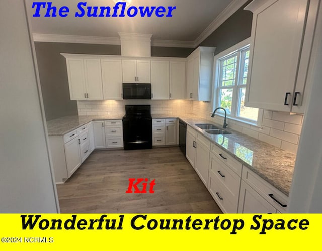 kitchen with black appliances, sink, white cabinets, light stone counters, and hardwood / wood-style flooring