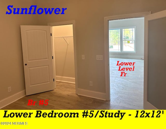 unfurnished bedroom featuring a walk in closet, hardwood / wood-style flooring, and a closet