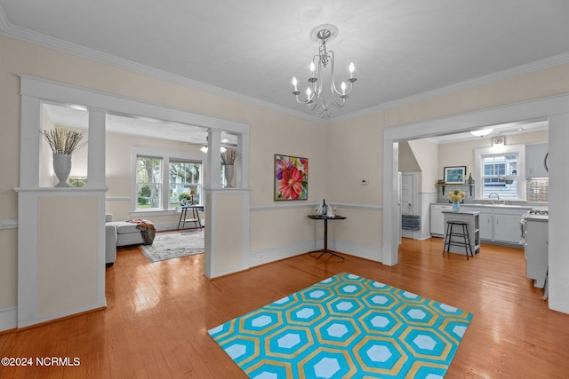 dining area featuring ceiling fan with notable chandelier, ornamental molding, and light hardwood / wood-style flooring