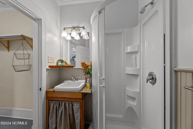 bathroom featuring ornamental molding, vanity, and a shower