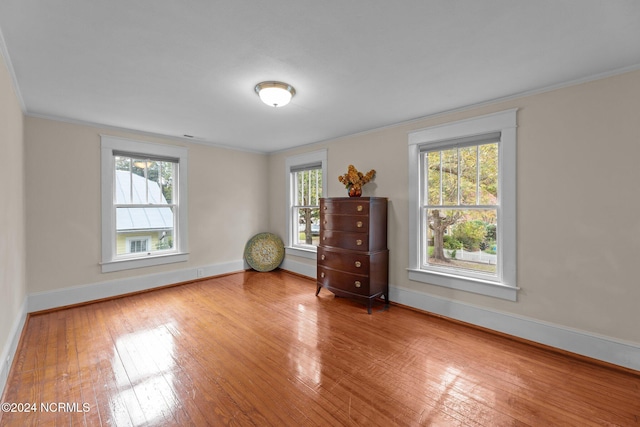 unfurnished room with crown molding and wood-type flooring