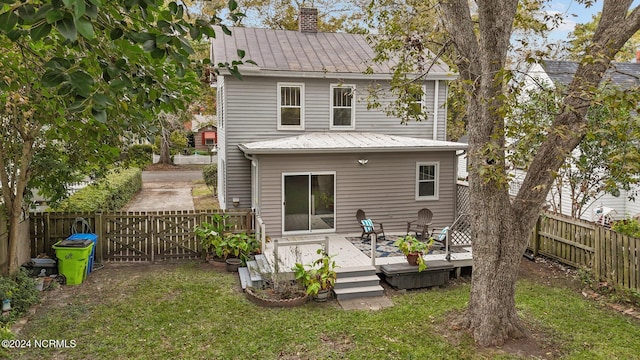 rear view of house featuring a lawn and a wooden deck