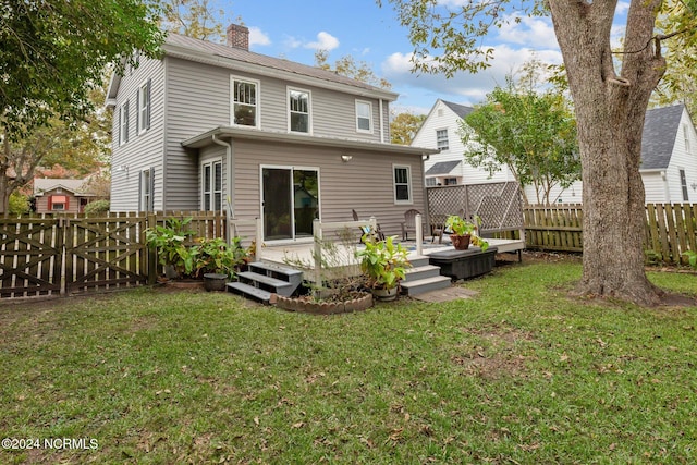 back of property featuring a deck and a yard