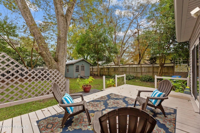 403 Ave D, New Bern, NC 28560 - view of patio featuring a fenced backyard, a deck, an outdoor structure, an outdoor fire pit, and a shed