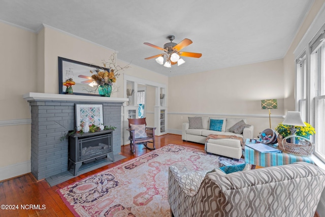 living room featuring ceiling fan, hardwood / wood-style flooring, and a wood stove