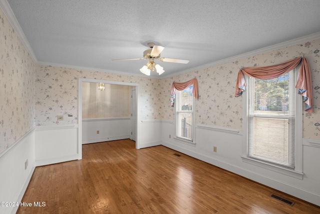 empty room featuring plenty of natural light, hardwood / wood-style floors, and a textured ceiling