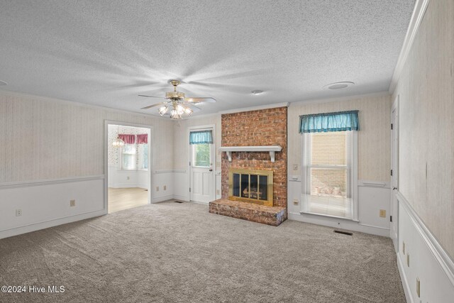 unfurnished living room with crown molding, light colored carpet, a textured ceiling, and a brick fireplace