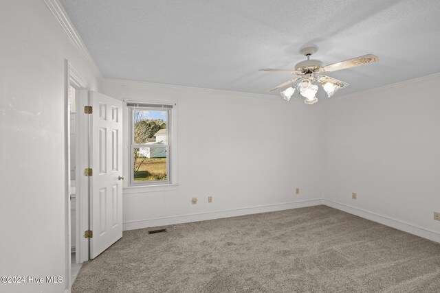 unfurnished bedroom featuring a closet, light colored carpet, a textured ceiling, and ornamental molding