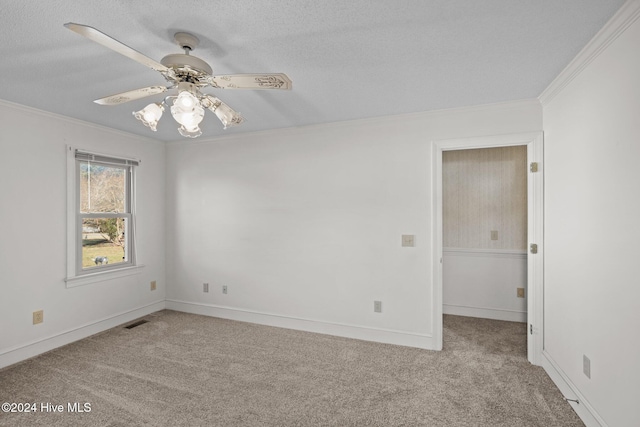 unfurnished room with a textured ceiling, light colored carpet, ceiling fan, and crown molding