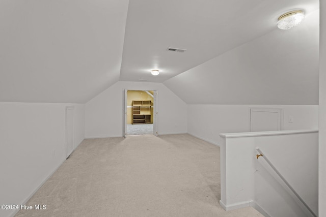 bonus room with light colored carpet and lofted ceiling