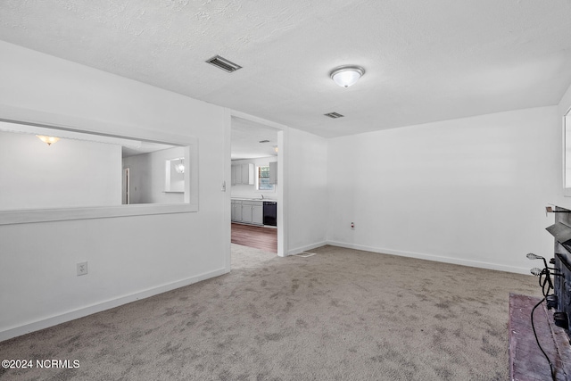 carpeted empty room featuring a textured ceiling