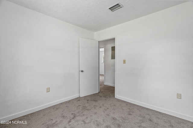 empty room featuring carpet and a textured ceiling