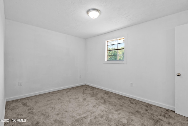 unfurnished room featuring a textured ceiling and carpet flooring