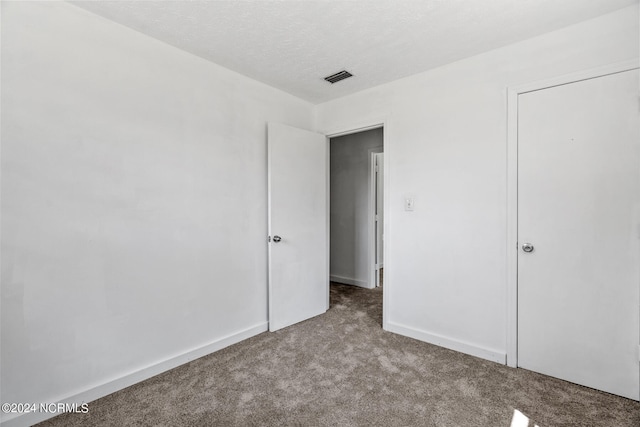 unfurnished bedroom with light carpet and a textured ceiling