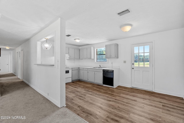 kitchen with black dishwasher, gray cabinets, white range oven, light hardwood / wood-style floors, and sink