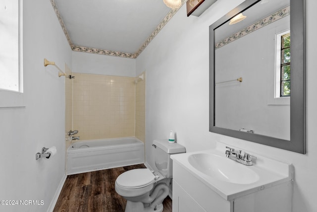 full bathroom featuring tiled shower / bath, vanity, wood-type flooring, and toilet