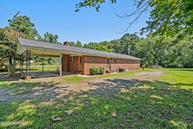 view of front of house featuring a front yard, central AC unit, and a carport