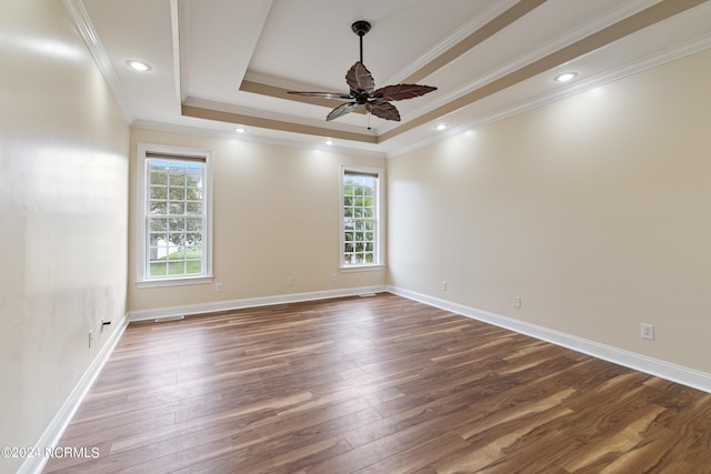 spare room featuring crown molding, ceiling fan, a tray ceiling, and dark hardwood / wood-style flooring