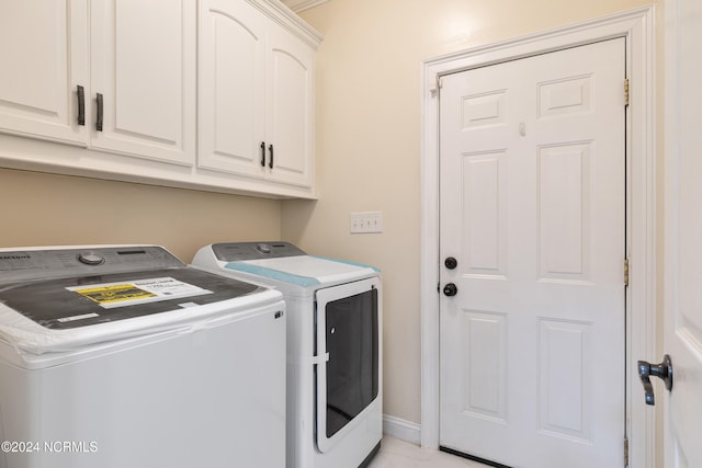 laundry room featuring washer and clothes dryer and cabinets