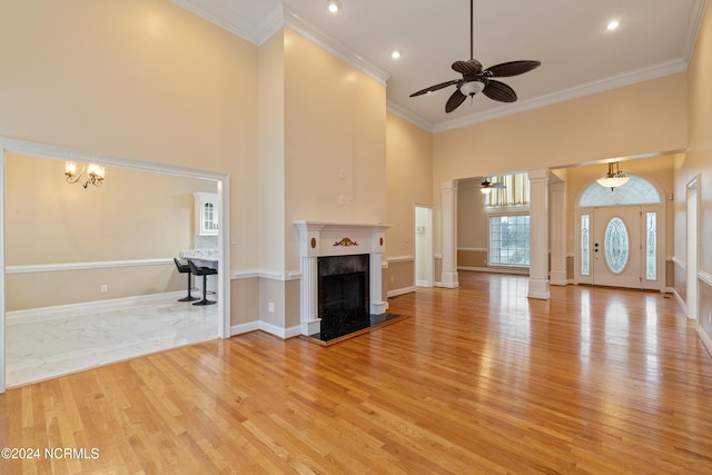 unfurnished living room featuring crown molding, light hardwood / wood-style flooring, and a high ceiling