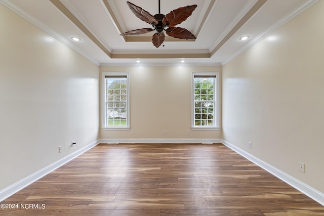 spare room featuring crown molding, a healthy amount of sunlight, and dark hardwood / wood-style flooring