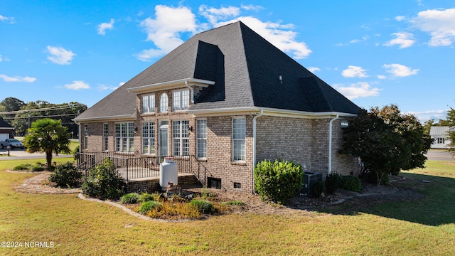 rear view of property with a wooden deck and a yard