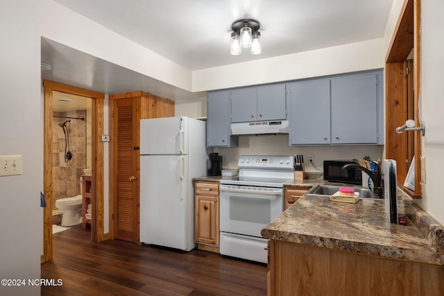 kitchen with white appliances, gray cabinetry, sink, dark hardwood / wood-style flooring, and dark stone countertops