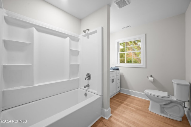 full bathroom featuring toilet, hardwood / wood-style flooring, vanity, and washtub / shower combination