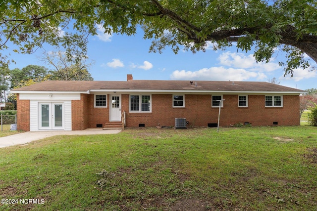 rear view of house with a yard, a patio area, central AC, and french doors