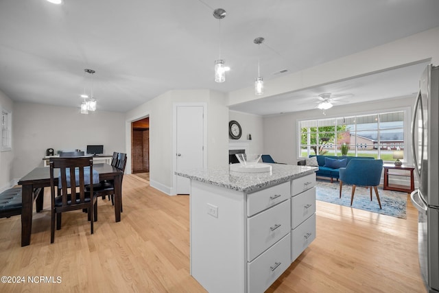 kitchen with ceiling fan, pendant lighting, light wood-type flooring, and stainless steel refrigerator