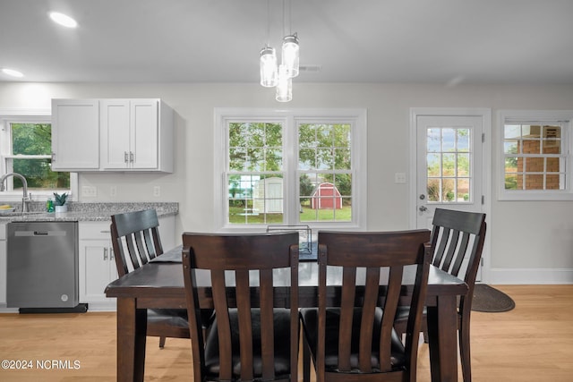 dining area with light hardwood / wood-style floors, a notable chandelier, and sink