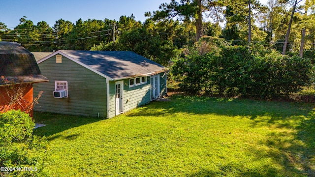 view of outdoor structure featuring a yard and cooling unit