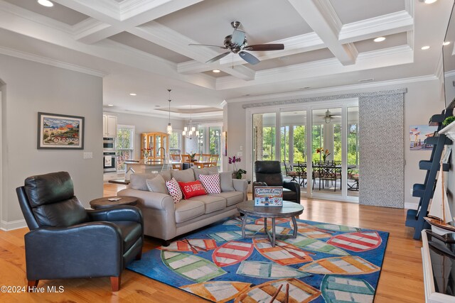 living area featuring beam ceiling, light wood-type flooring, coffered ceiling, and ornamental molding